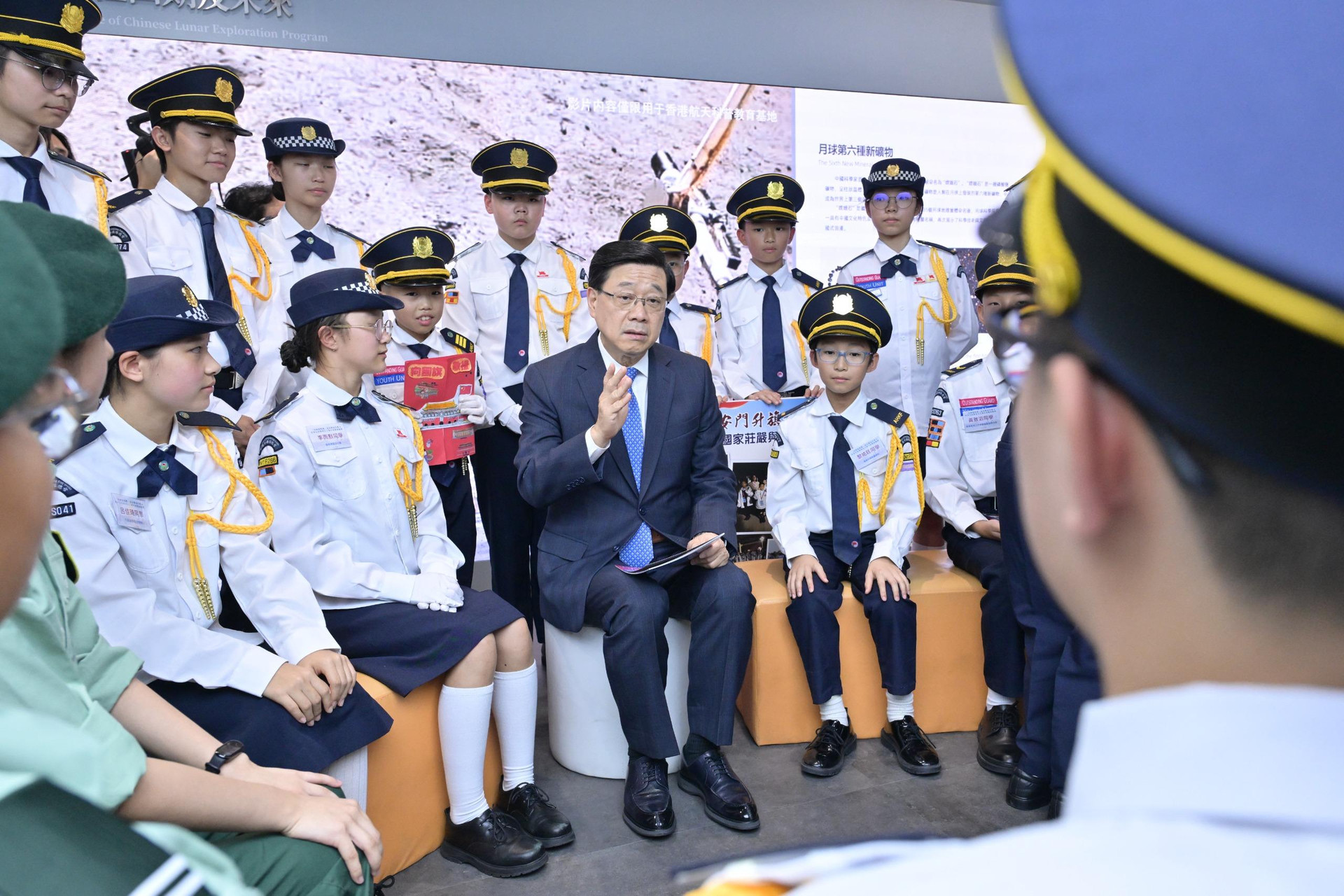官員與青少年制服團隊交流的常規活動照片,資訊量有限。(32/100) 官員與青少年制服團隊交流的常規活動照片,資訊量有限。
