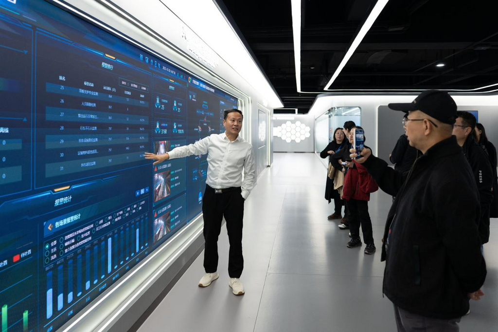 云鼎科技工业互联网事业部总经理王磊(左一)为媒体记者介绍大模型运行情况