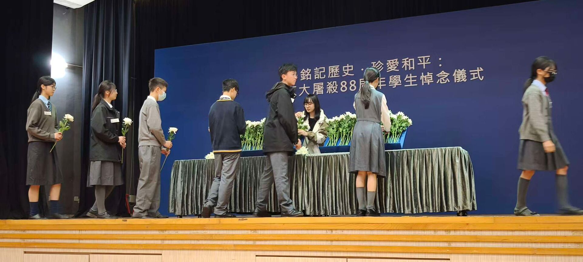 相片8:學生輪流上台為南京大屠殺死難者獻花