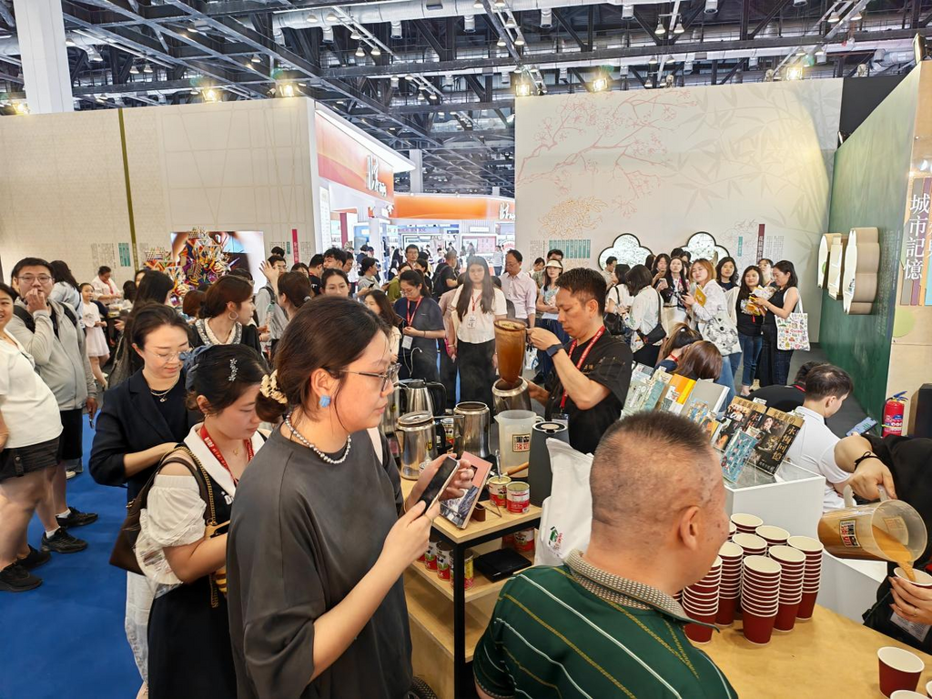 資深港式奶茶技藝人謝忠德製作奶茶,吸引大批觀眾駐足品嘗