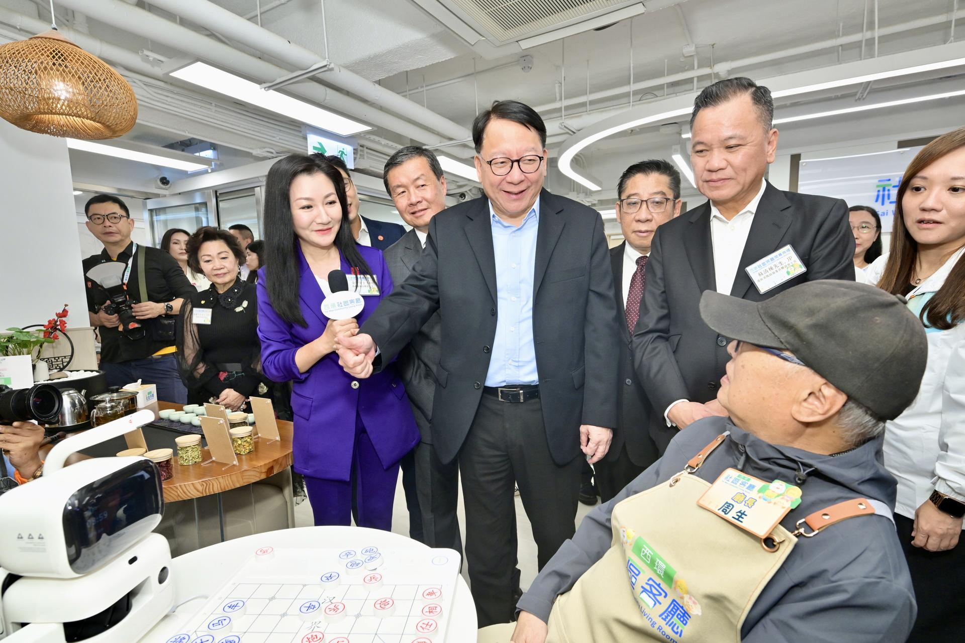 政务司司长陈国基与客厅会员亲切交流，听取会员分享使用AI象棋机械人的心得。