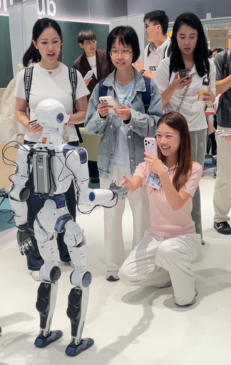 一名参加者于路演与人形机器人握手互动