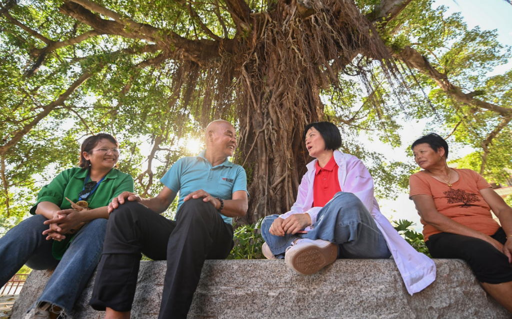 赤土社是厦门市海沧区东孚街道下辖的一个自然村,常住人口800多人。以前发展落后,很多年轻人选择外出打工。李佩珍是一名来自台湾的规划师,有10多年参与乡村建设和社区营造的经验,2014 年随团队来到当地。经过她的鼓励和推动,如今,赤土社的公益书院、陶艺馆等产业风生水起,村容村貌也发生巨大变化,吸引了众多年轻人回乡创业。图为 7月11日,李佩珍(右二)在和村民聊天(图:新华社) 截屏2022-10-04 下午3.50.08