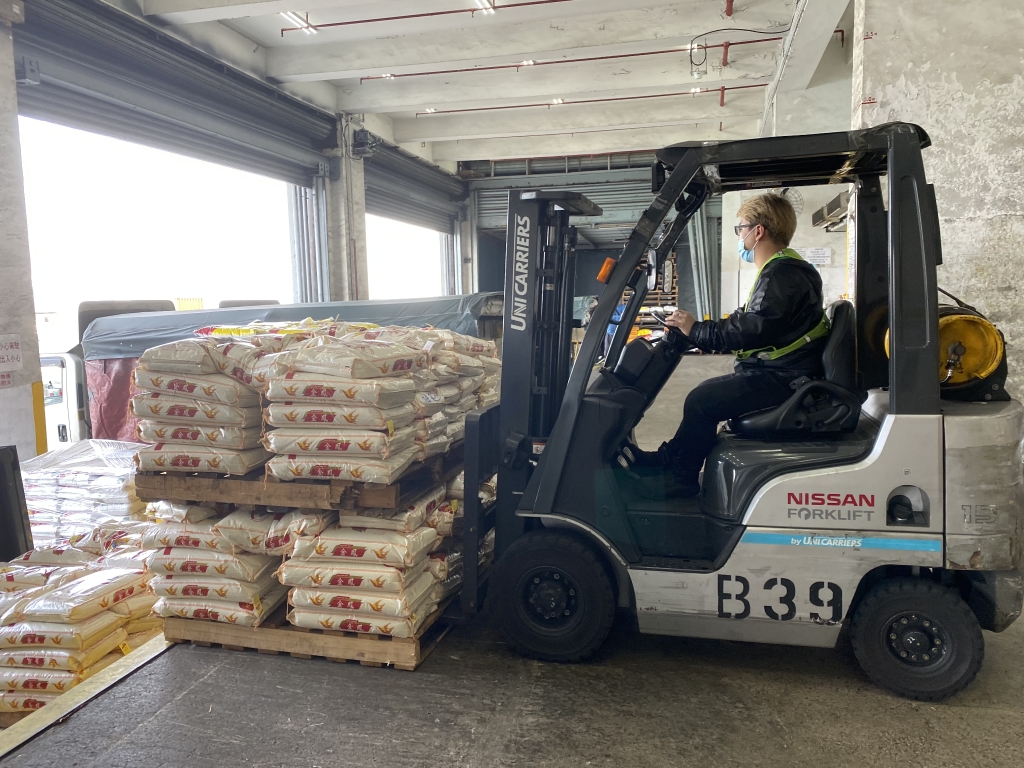 倉庫操作人員正在加班加點進行大米進出倉操作