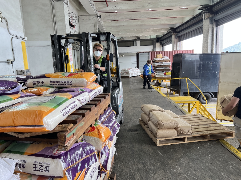 仓库操作人员正在加班加点进行大米进出仓操作