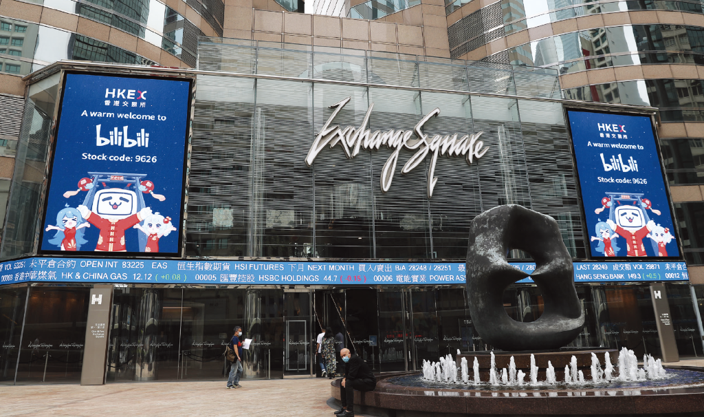 不少新经济企业借助香港便利的上市制度回流香港实现美、港两地上市。图为港交所门前大屏幕上显示哔哩哔 哩股份代码。中概股哔哩哔哩 2021年3月在香港第二上市(图:新华社) WX20220505-161929@2x