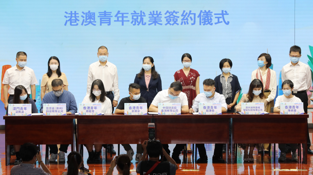 2021 年 8 月 27 日,港澳青年学生南沙“百企千人”实习计划结业礼在广东省广州市南沙区举行。6 周时间里, 共计 110 余名港澳青年学生参加实习;此次实习计划促成 8 名港澳青年与驻区央企、智能科技公司、港资企业、 社会组织等 5 个单位签订劳动合同。图为港澳青年与意向入职单位签订劳动合同(图:中新社) WX20220728-195340@2x