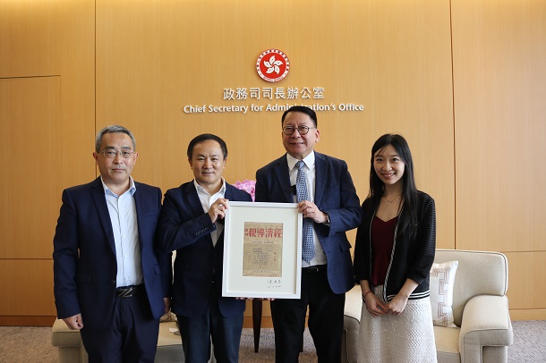 香港经济导报社长丁时照(左二)赠送《经济导报》1947年1月1日创刊号封面1:1复制品纪念品给政务司司长陈国基(右二)。 20230728121826696