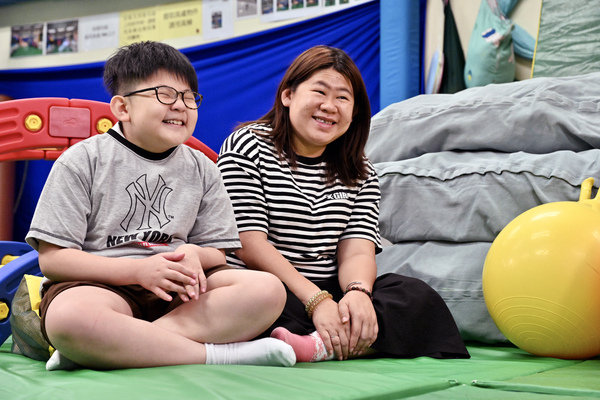母子同行: 书写能力提升,轩仔(左)笑逐颜开;妈妈宋太则期望儿子持续进步。 20240516170203831