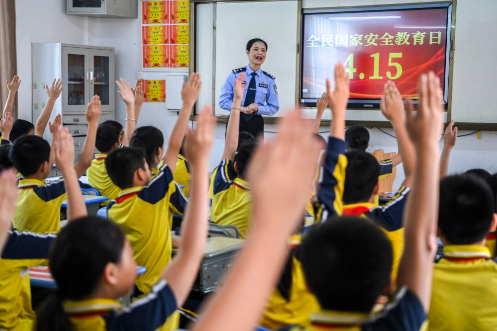 2024年4月15日,在廣西興業縣一所小學內,公安民警在講解國家安全相關知識的過程中與學生們互動。新華社記者 攝 20240722f47f37dda3d04fce9408f3f7ab934876_2024072292488e137659483f80d8289fa7958f1e